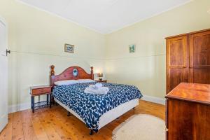纳鲁马12 Bluewater Drive Narooma的一间卧室配有一张带蓝色和白色棉被的床