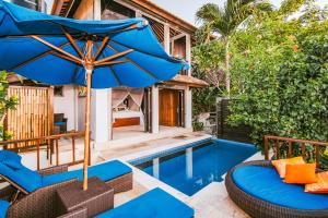 蓝梦岛马尼斯别墅酒店的游泳池旁带椅子和遮阳伞的天井