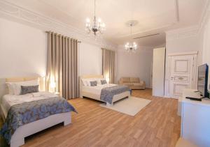 地拉那Vila Ferdinand Modern Rooms In Tirana's Center的一间带两张床的卧室和一间客厅