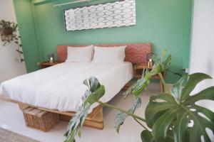 琅勃拉邦Baan Pila的一间卧室配有一张床和盆栽植物