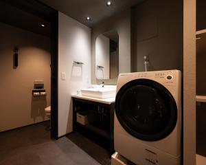 京都MIMARU SUITES KYOTO CENTRAL的一间带洗衣机和水槽的浴室