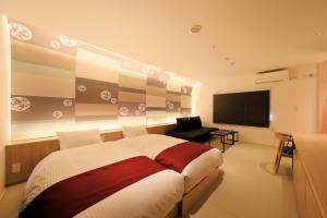 富士河口湖富士温泉寺梦殿日式旅馆的一间卧室配有一张大床和一台平面电视