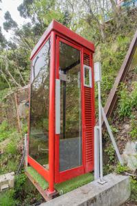 热海ゴンドラヴィラ イン熱海的山顶上的一个红色电话亭
