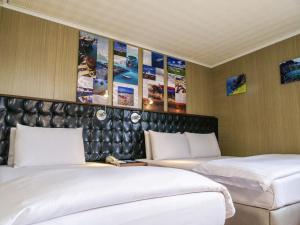 马公澎湖和田大饭店 的墙上贴有海报的房间里设有两张床