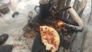 赤井川Ski base的火上拿着比萨饼的人