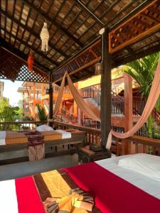 华欣Rainforest Huahin Village Hotel的一间卧室设有两张床和吊床
