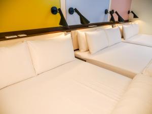 马公澎湖和田大饭店 的一间白色枕头的房间的一排床位