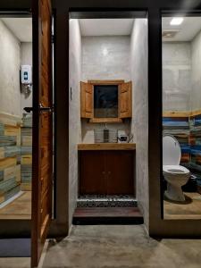 科隆Michel'inn Coron的一间带卫生间和水槽的浴室以及一台电视。