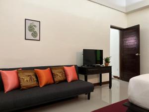 华欣Rainforest Huahin Village Hotel的带沙发和电视的客厅