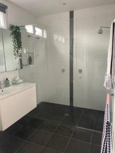 墨尔本Entire contemporary home in Ascot Vale的带淋浴和盥洗盆的浴室