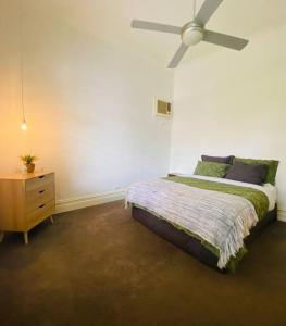 墨尔本Entire contemporary home in Ascot Vale的一间卧室配有一张床和吊扇