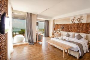 金巴兰普拉布金巴兰湾温泉度假村 的一间卧室配有一张大床和一张桌子