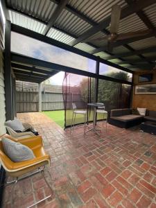 墨尔本Entire contemporary home in Ascot Vale的庭院设有遮阳篷、椅子和桌子