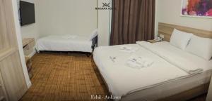 埃尔比勒Niagara Hotel Erbil的酒店客房设有两张床和电视。