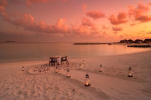 北马累环礁VARU by Atmosphere - Premium All Inclusive with Free Transfers的沙滩上的桌椅,沙滩上灯光照亮