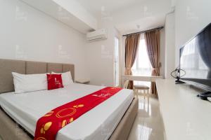 日惹RedLiving Apartemen Barsa City by Ciputra - WM Property的酒店客房,配有床和电视
