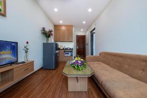 河内Granda Quan Hoa Apartment的客厅配有沙发和鲜花桌