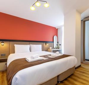 伊斯坦布尔BayMari Suites City Life的卧室配有一张白色大床和红色墙壁