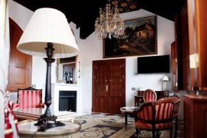 塞维利亚塞维利亚雅典娜酒店的客厅配有台灯和桌椅