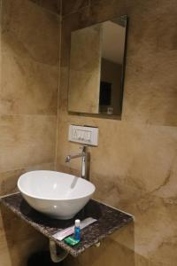 纳威孟买Hotel Pub Street Inn的浴室设有白色水槽和镜子