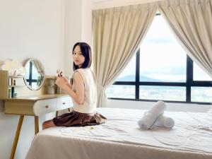 吉隆坡Modern Muji Inspired Design, Bandar Menjarala, near to DesaParkCity 2 Bedrooms Suite的坐在镜子前的床上的女人