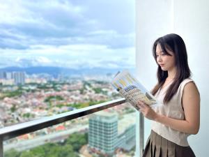 吉隆坡Modern Muji Inspired Design, Bandar Menjarala, near to DesaParkCity 2 Bedrooms Suite的一位在建筑物里读书的女人