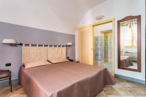 博萨Locanda di Corte的一间卧室配有一张床和镜子