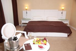 巴库琥珀酒店的酒店客房,配有一张床和一张桌子,上面有盘子的食物