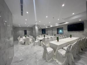 麦加فندق بياك أوتيل الروضة的宴会厅配有白色的桌子和白色的椅子