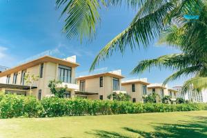 金兰Lumina Villas Cam Ranh, Bai Dai beach luxury resort villas的一排公寓楼,有棕榈树