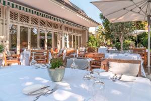 埃特林根埃布普林斯餐厅酒店的一间设有白色桌子和遮阳伞的餐厅