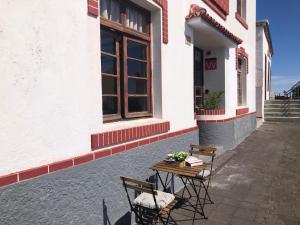 丰卡连特德拉帕尔马Casa Las Enanitas II (Casa Elias)的桌子和椅子坐在大楼外