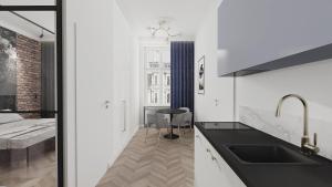 卡托维兹Deco Apartments Mariacka 8的一个带水槽的厨房和一张位于客房内的床