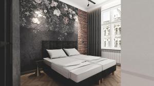 卡托维兹Deco Apartments Mariacka 8的一间卧室设有一张床和砖墙
