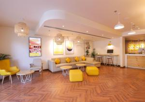 贾朗达尔Bloom Hotel - Jalandhar的带沙发和黄色椅子的客厅