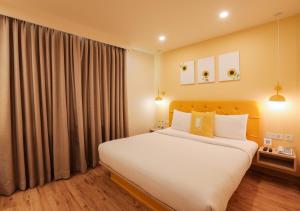 贾朗达尔Bloom Hotel - Jalandhar的一间卧室设有一张大床和一个大窗户