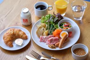 金泽KUMU Kanazawa by THE SHARE HOTELS的餐桌,带两盘食物和一杯咖啡的桌子