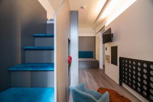 雷根斯堡威登霍夫酒店的客房设有带蓝色座椅的楼梯和电视。