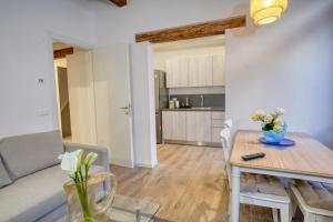 威尼斯Ecco Suites Apartments的客厅以及带桌子和沙发的厨房。