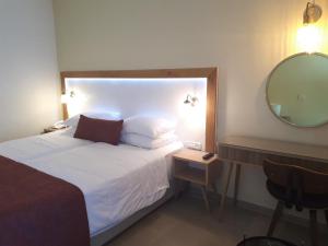 内坦亚瑞兹丹斯酒店的卧室配有一张带镜子和椅子的白色床