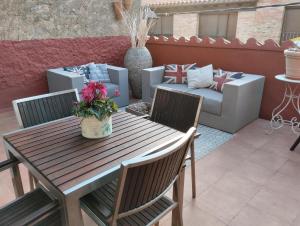 阿尔内斯LES LLÚDRIGUES. Casa Loft con encantadora terraza的庭院配有木桌、椅子和沙发。