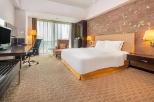 西安西安绿地假日酒店的酒店客房设有一张大床和一张书桌。
