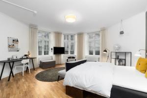 哥本哈根易卜生酒店的白色卧室配有床、书桌和桌子