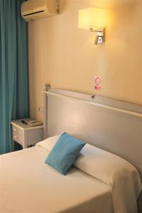 埃尔阿雷纳尔索尔海滩酒店的一间卧室配有一张带蓝色枕头的床