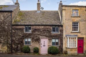 斯托昂泽沃尔德Whitsun Cottage的粉红色门的旧砖屋