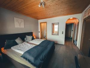 米尔施塔特兰玛斯多尔夫客栈酒店的一间卧室设有一张床和木制天花板