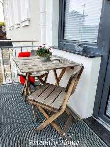 BrenigFriendly Home - Einzelappartement "Trust" Köln Bonn Phantasialand的门廊上的木桌和椅子