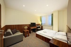 科希策中心会议酒店的酒店客房配有一张床、一张沙发和一张书桌。