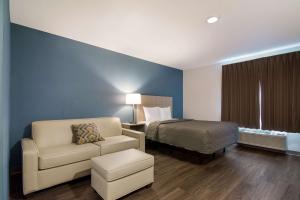 莫里斯维尔WoodSpring Suites Morrisville - Raleigh Durham Airport的配有一张床和一把椅子的酒店客房