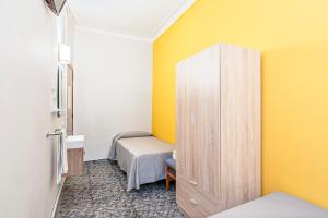 巴塞罗那亚圣安娜旅馆的小房间,设有床和黄色的墙壁